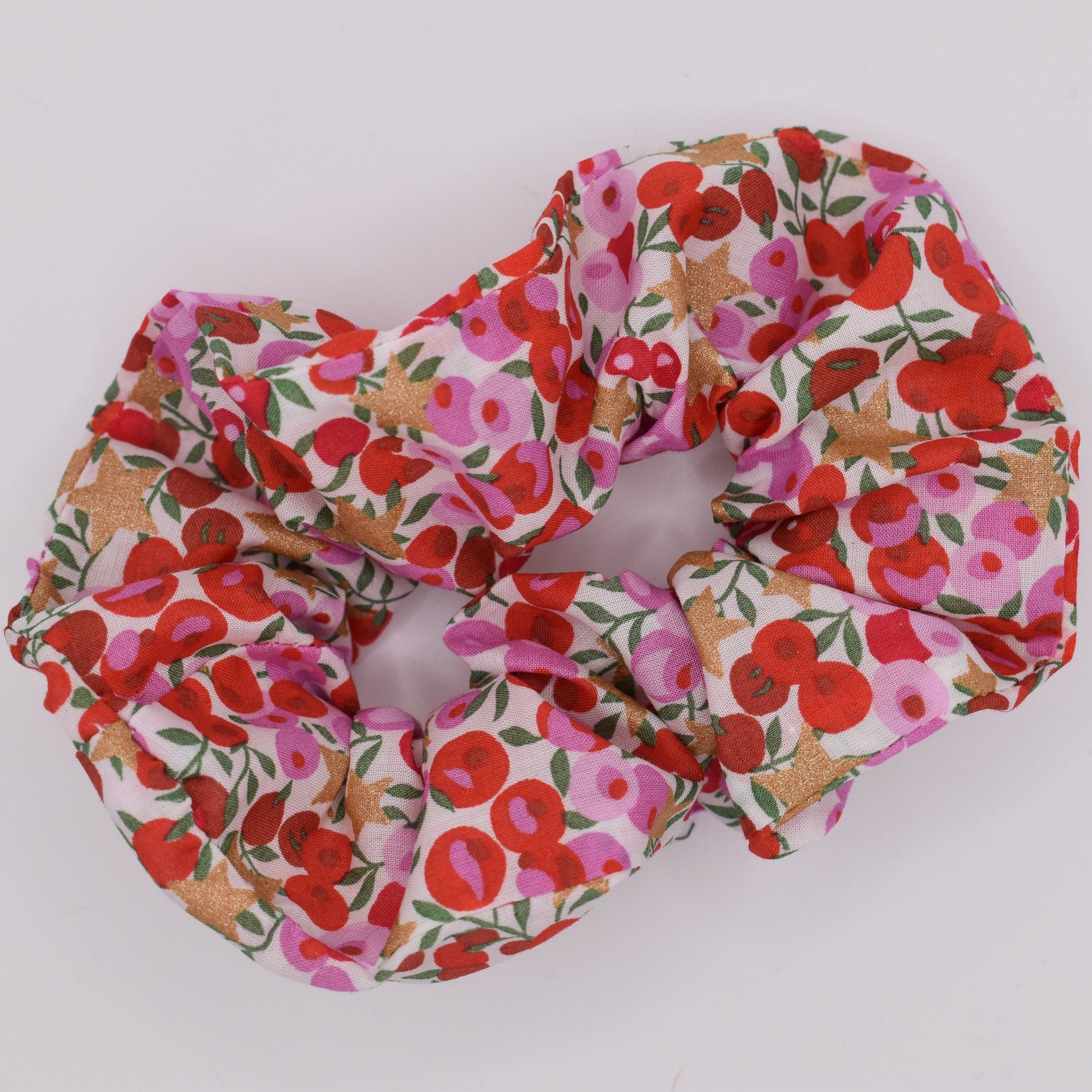 A Liberty print hair scrunchie for girls using Wiltshire Star Pink fabric and pattern. Top down view