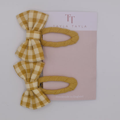 A set of yellow gingham bow hair clips for girls. Fabric material. Top view. Made by Tayla Tayla
