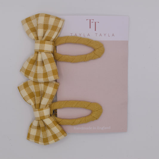 A set of yellow gingham bow hair clips for girls. Fabric material. Top view. Made by Tayla Tayla